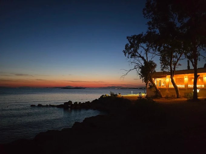 Το Panorama Restaurant φωτισμένο δίπλα στη θάλασσα μετά το ηλιοβασίλεμα
